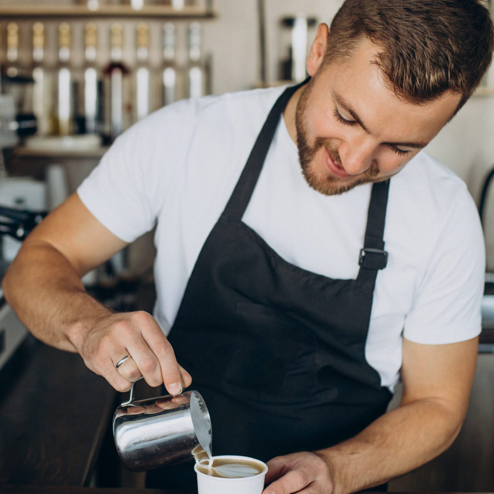 Male barista preparing cappuccino in a coffee shop